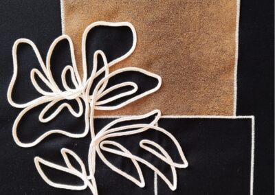 Bordado con aplicación y flor en cordón